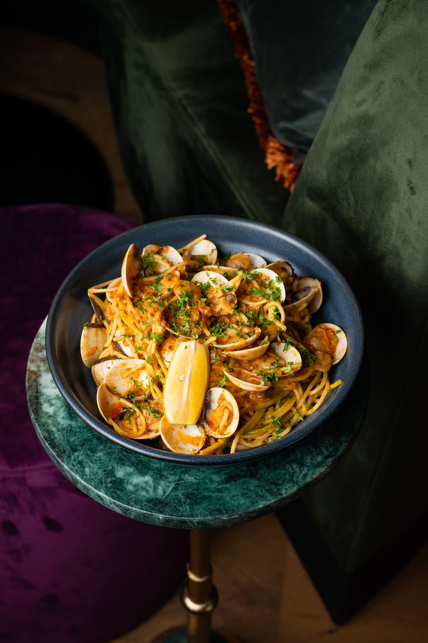 Spaghetti vongole met citroen op een groenmarmeren tafeltje